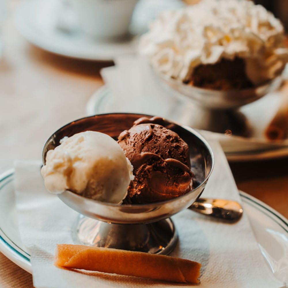 Coupe de glace chocolat et vanille servie en coupe métal avec tuile croustillante et café expresso