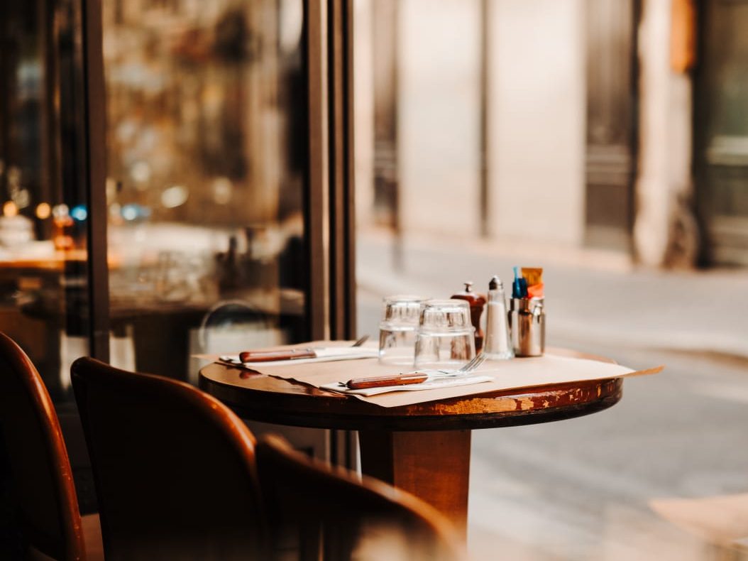 Lumière du matin traversant la vitrine du Café Gallery et éclairant une table de bistrot dressée